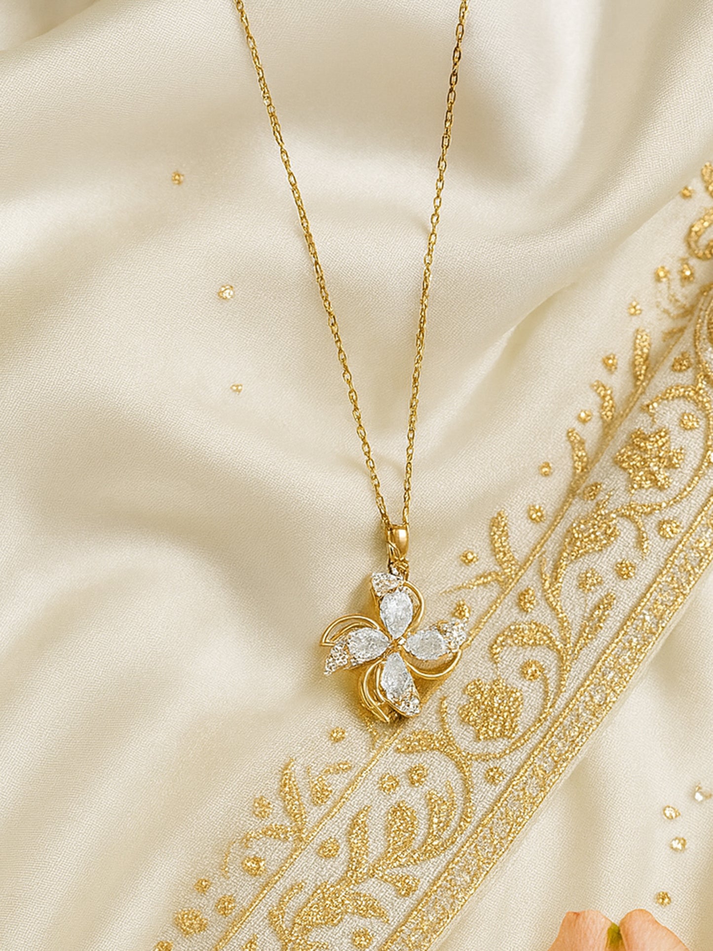 Close-up of one of the latest gold necklace designs, highlighting the intricate gold link chain and a kinetic spinning flower charm 
