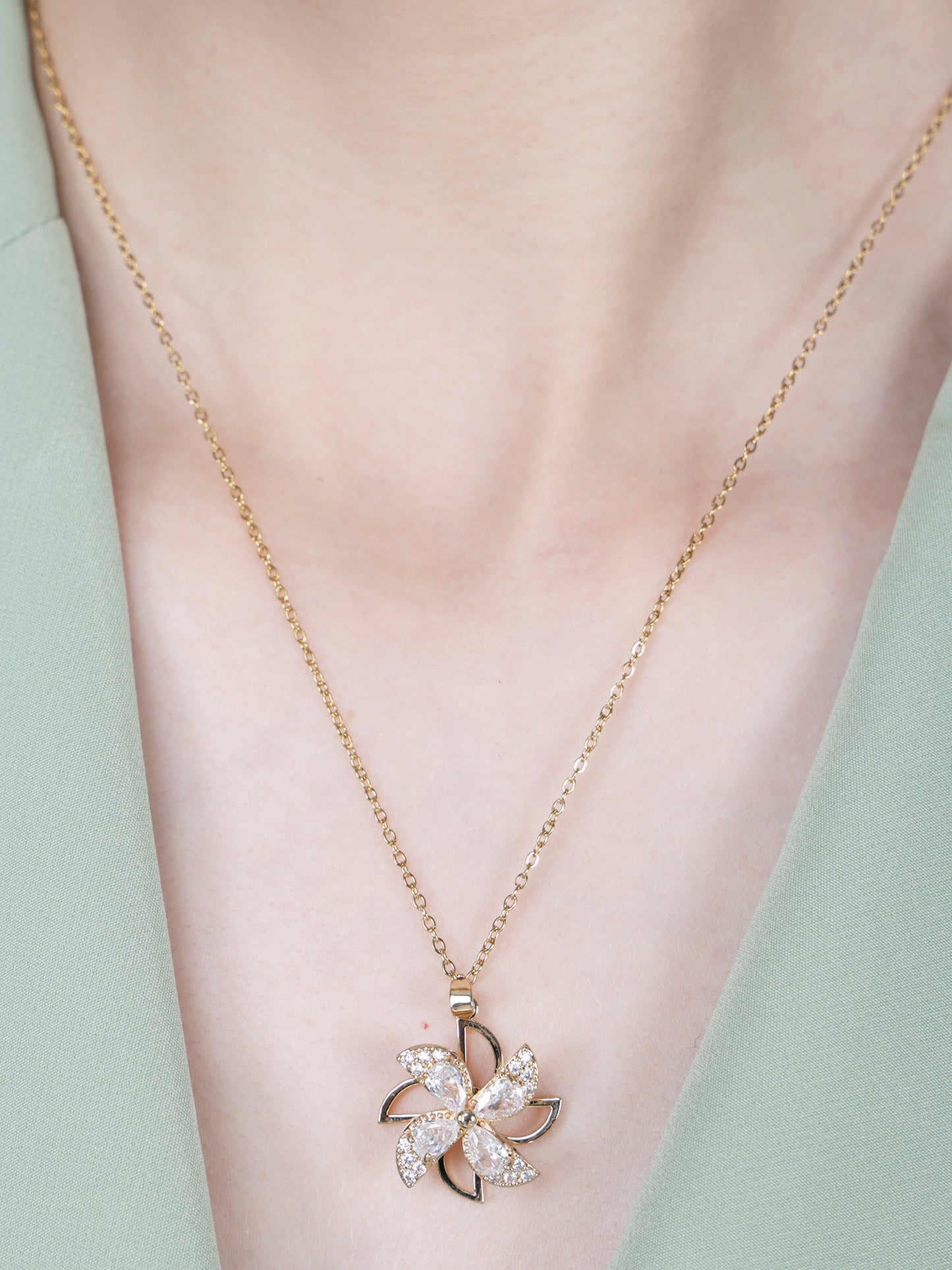 Light weight gold necklace with a windspinner-style floral pendant 