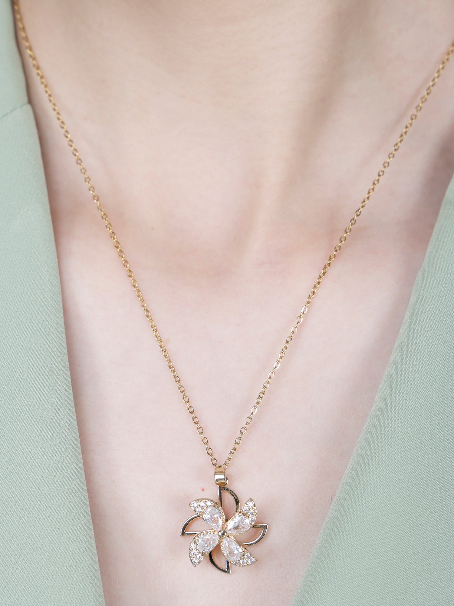 Light weight gold necklace with a windspinner-style floral pendant 