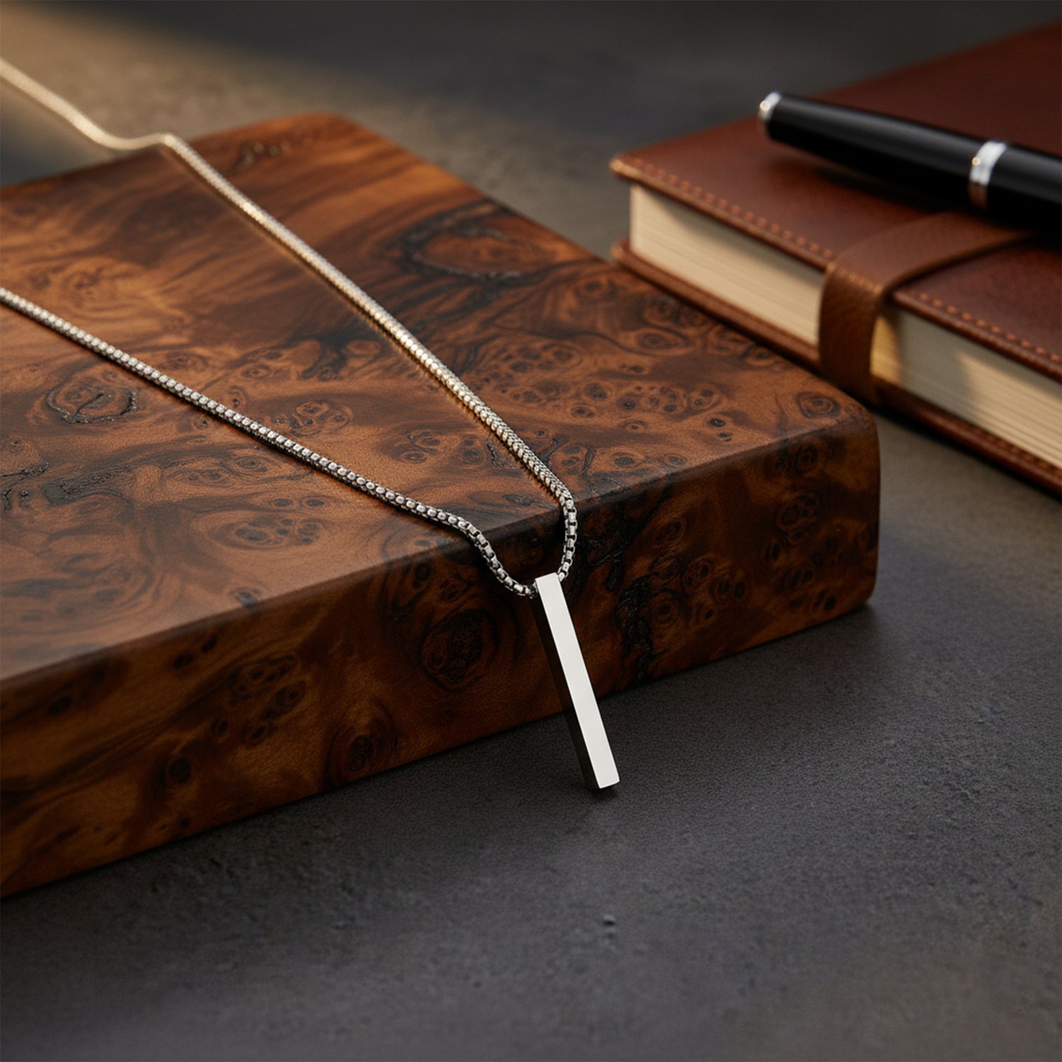 Men’s chunky silver necklace styled on a rustic wooden box