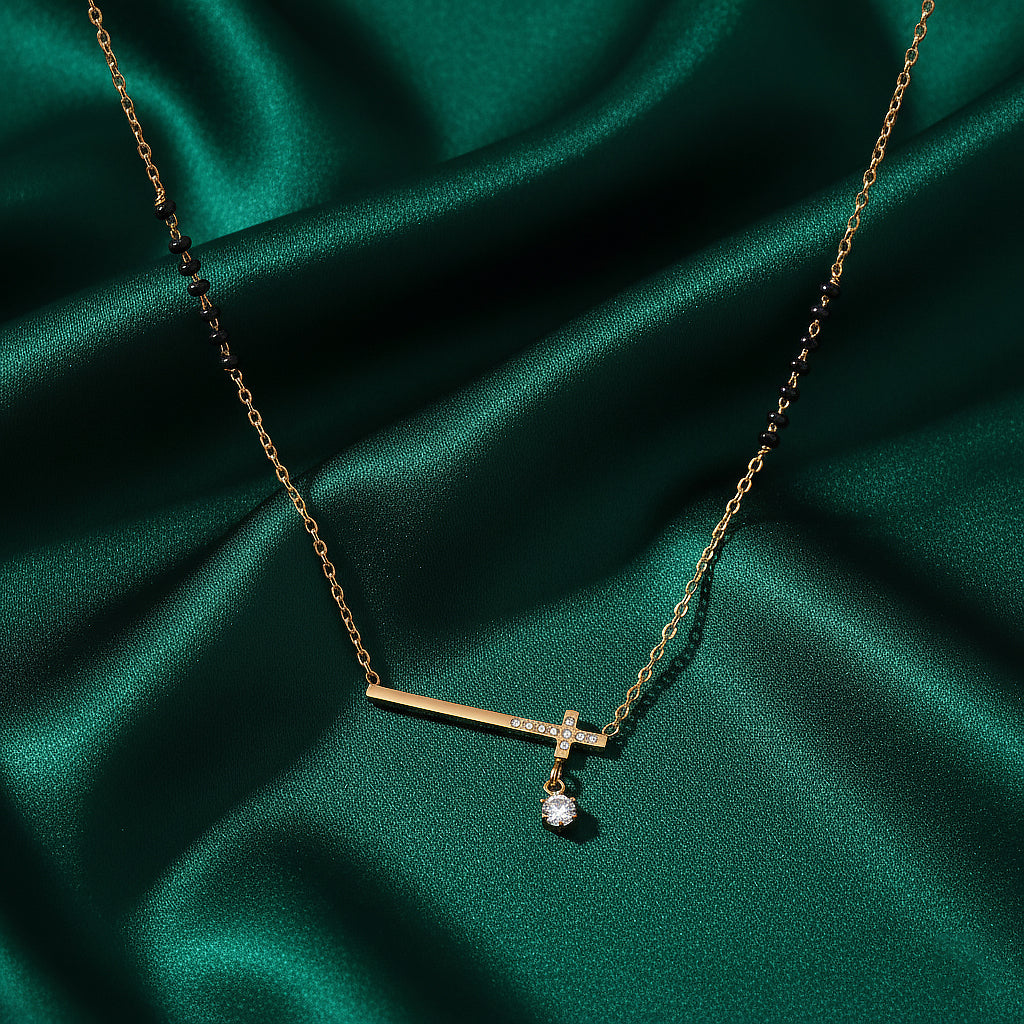 Modern mangalsutra design with gold bar pendant, solitaire drop, and black beads on green satin fabric