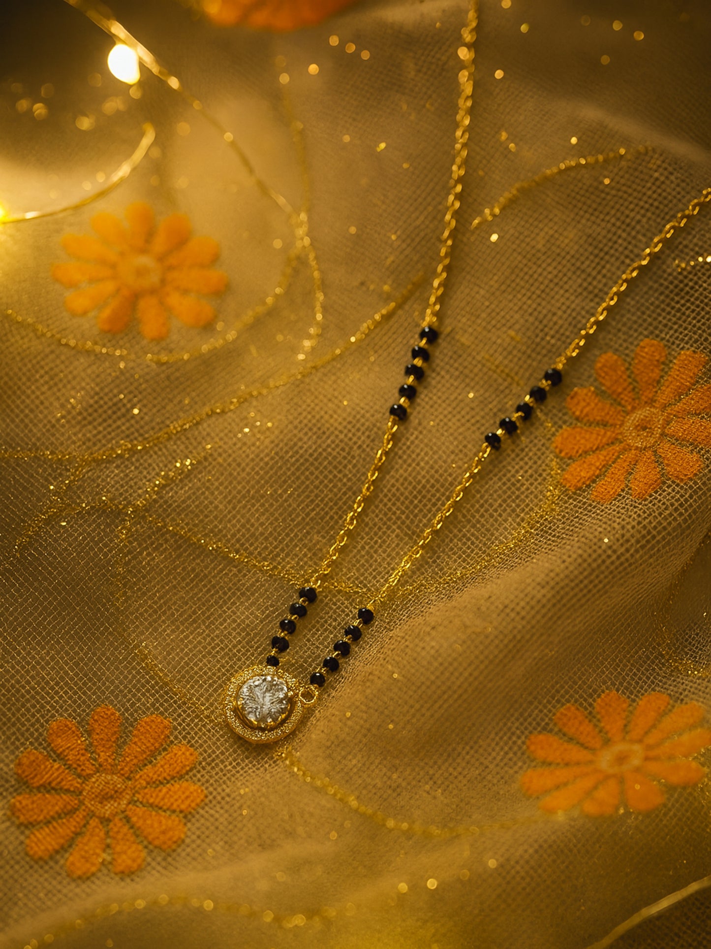 Close-up of a glamorous gold plated mangalsutra design with a solitaire stone, photographed in warm, bright light