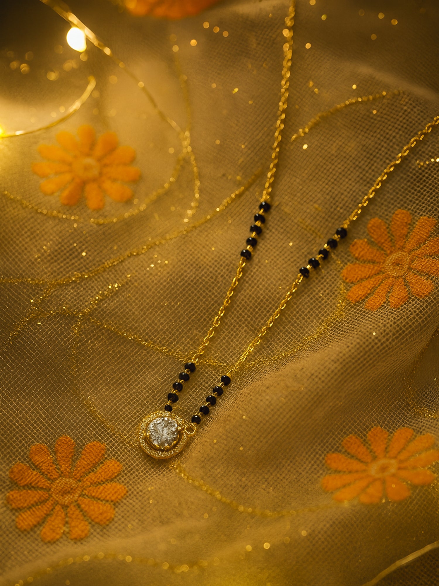 Close-up of a glamorous gold plated mangalsutra design with a solitaire stone, photographed in warm, bright light