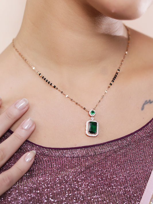 Elegant mangalsutra design with a green stone pendant worn on the neckline