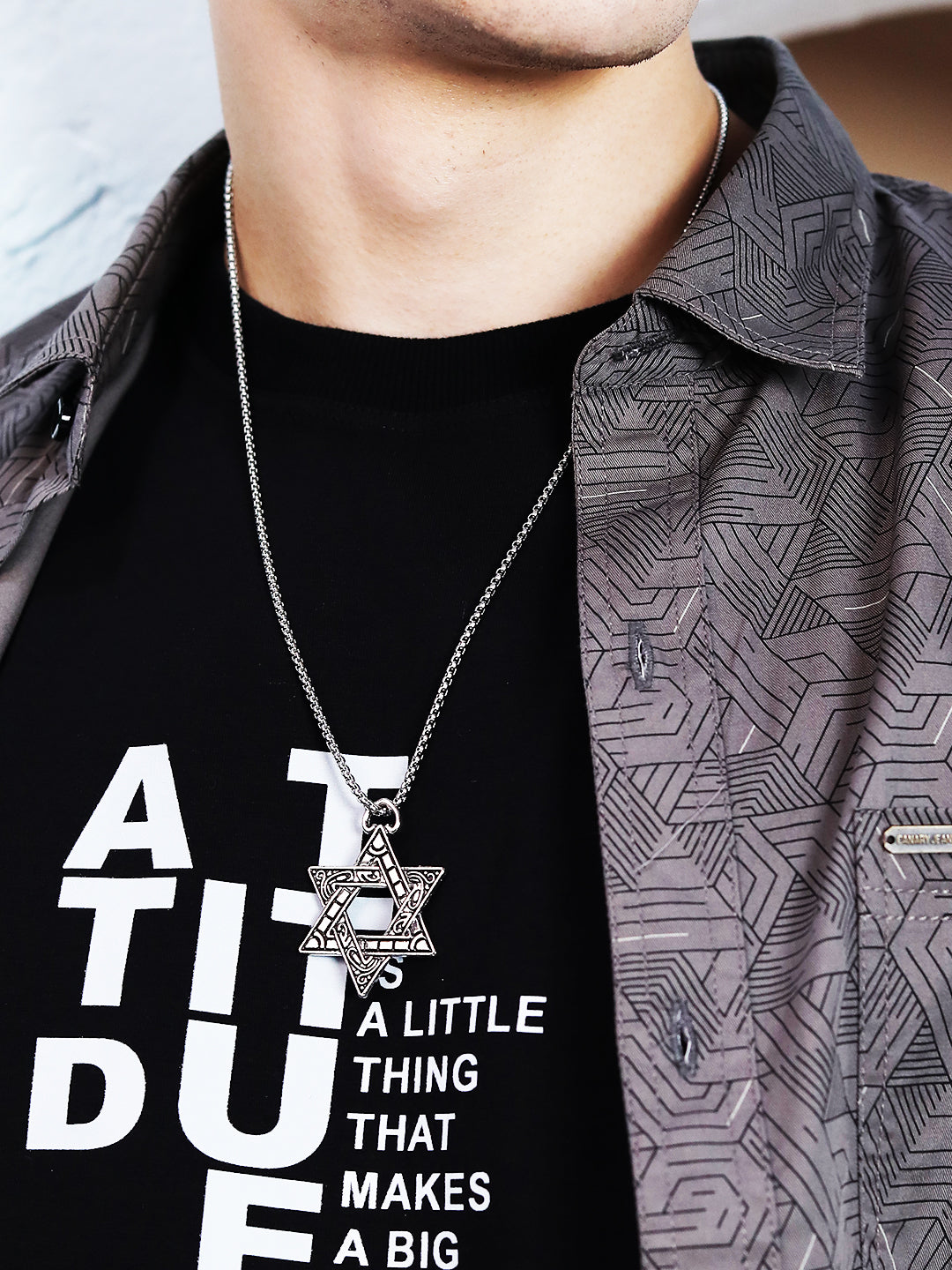 Pendant chain necklace with engraved star-shaped pendant worn by a model
