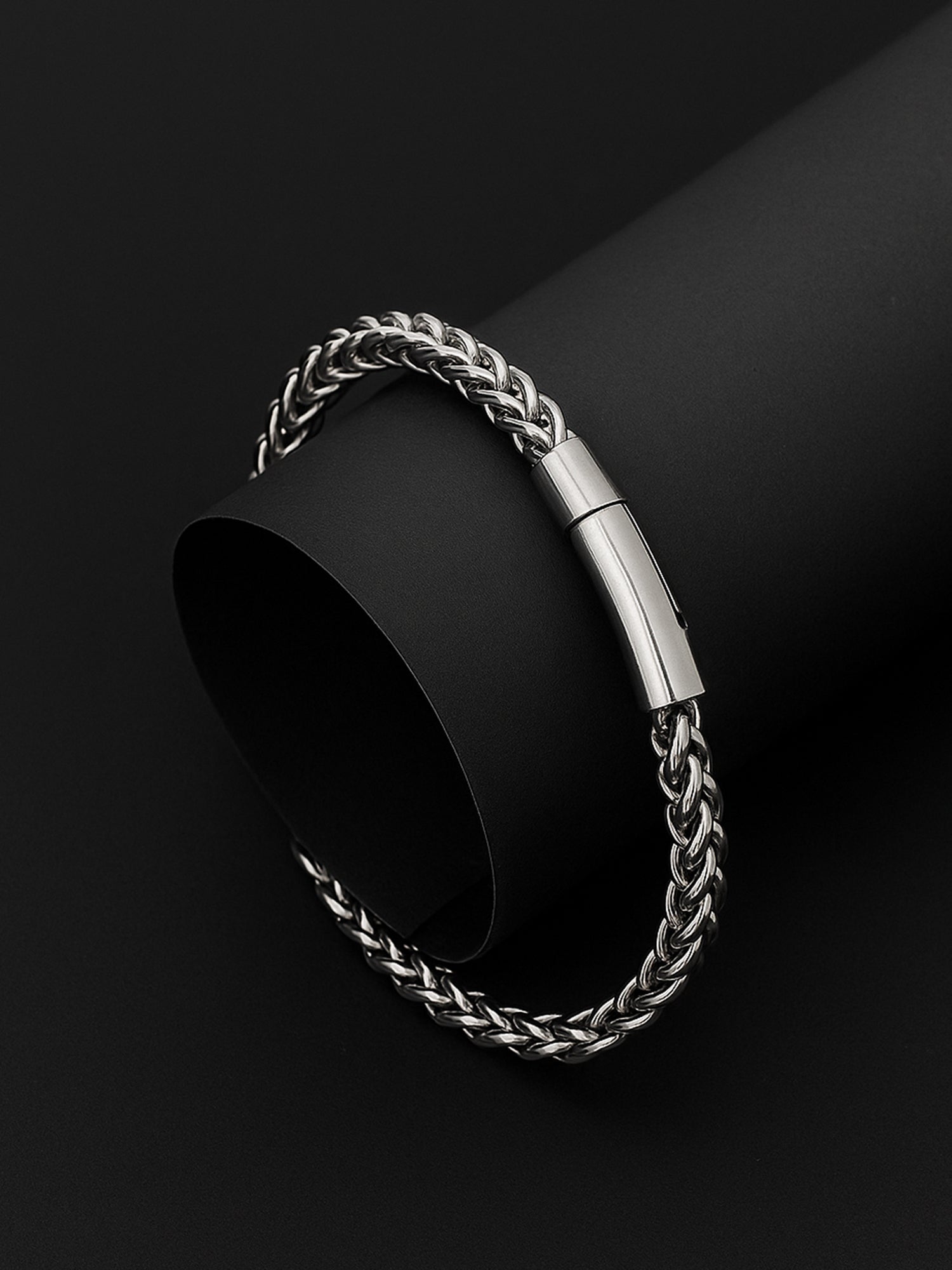 Sterling silver bracelet for men with a sleek braided chain and magnetic clasp on a black background.