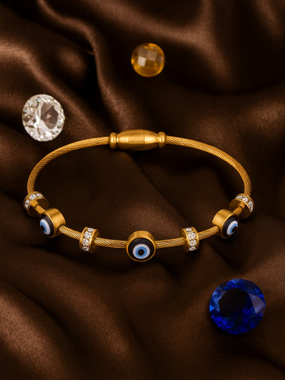 Elegant gold bracelet for women featuring blue evil eye charms and crystal spacers on a brown silk background.