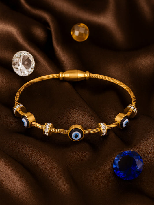 Elegant gold bracelet for women featuring blue evil eye charms and crystal spacers on a brown silk background.