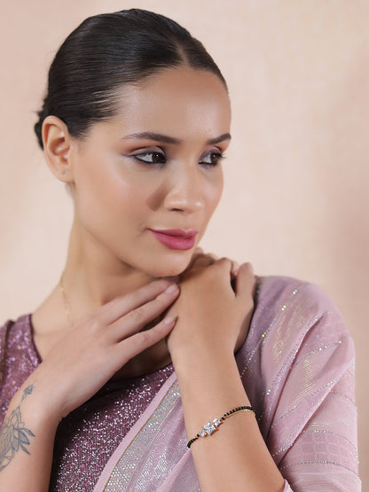 Woman wearing a daily wear mangalsutra design in gold, styled with a sparkly blouse and pastel saree.