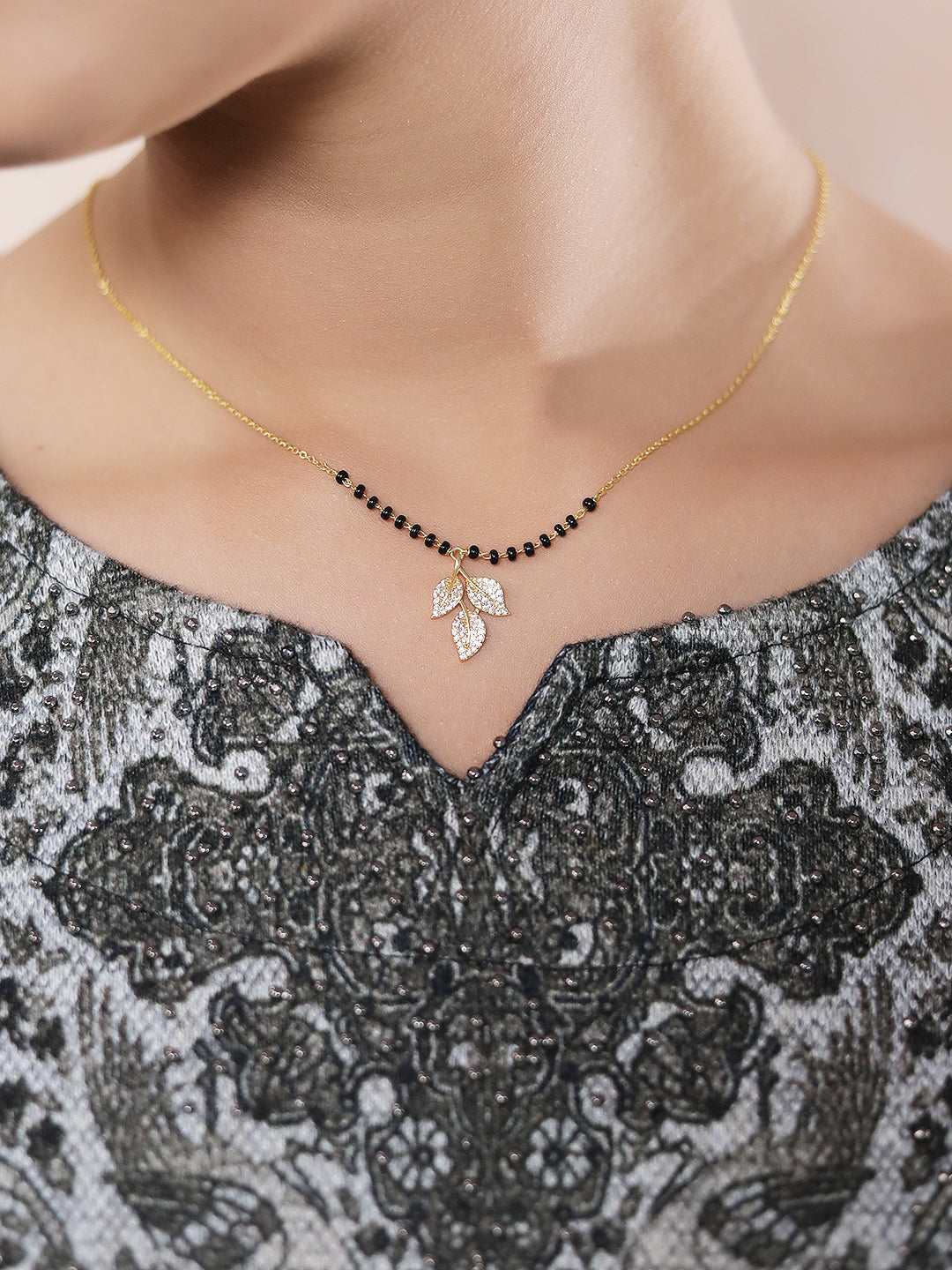 “Traditional mangalsutra design with black beads and a crystal leaf pendant
