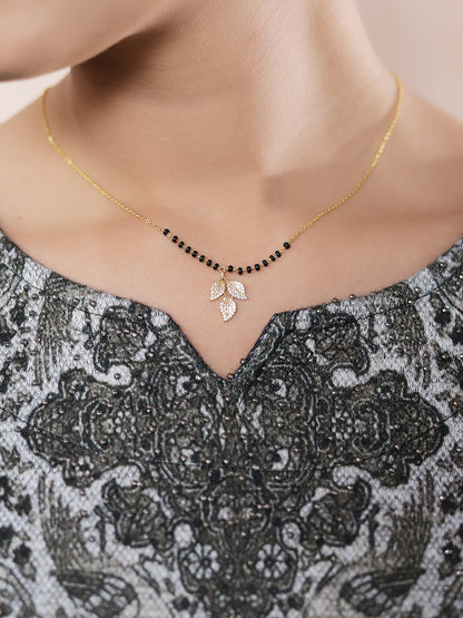 “Traditional mangalsutra design with black beads and a crystal leaf pendant