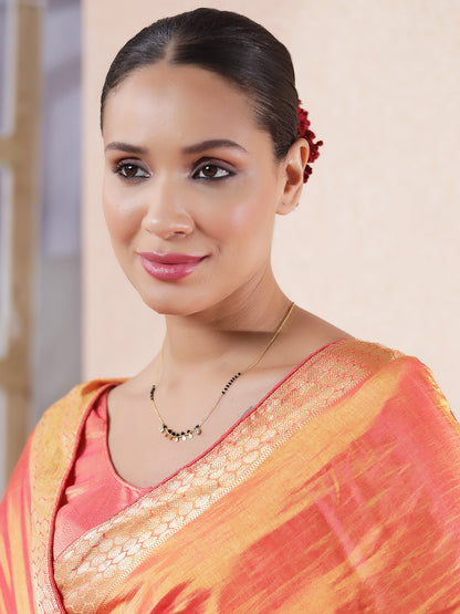 Daily wear mangalsutra design in gold with black beads and dainty charm, worn with traditional saree