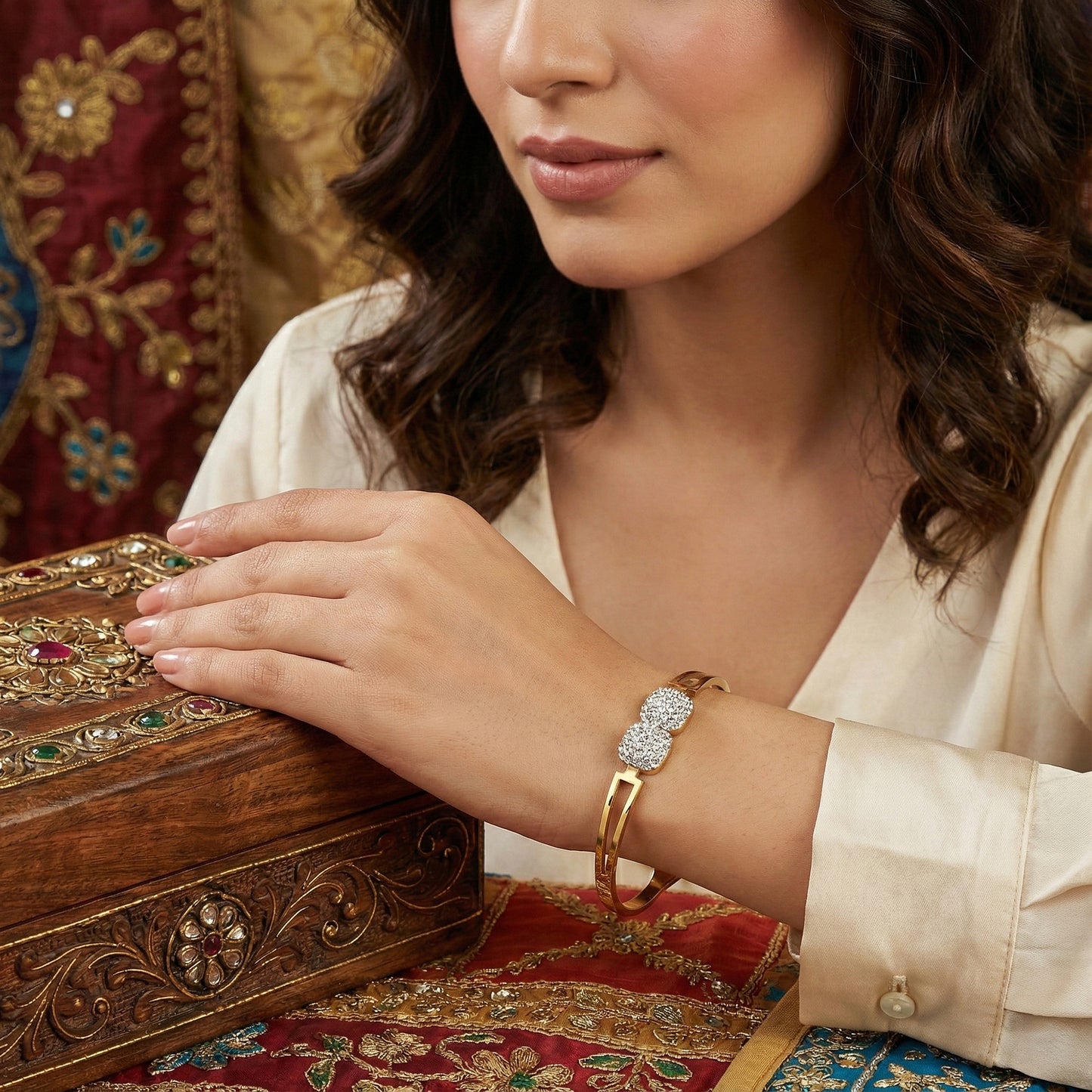 Model wearing a hand bracelet for women while resting her hand on a wooden jewelry box.