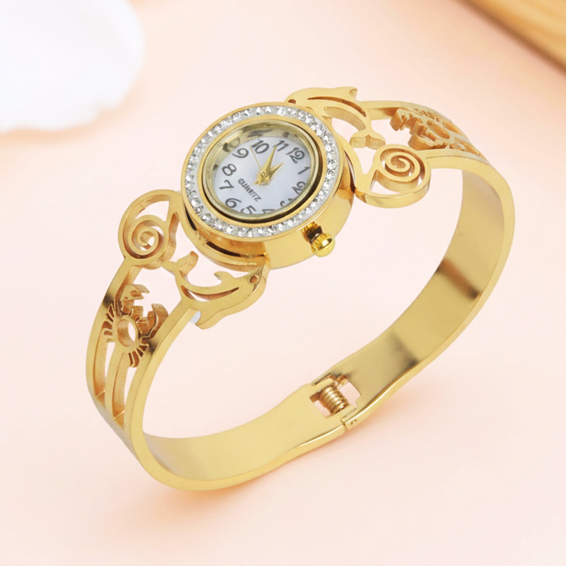 Elegant gold bracelet for women with a round crystal-encrusted watch face and openwork metal detailing.