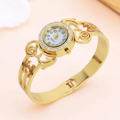 Elegant gold bracelet for women with a round crystal-encrusted watch face and openwork metal detailing.