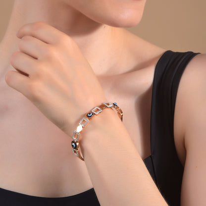 A delicate hand bracelet for women with a rose gold finish and evil eye protection charms.