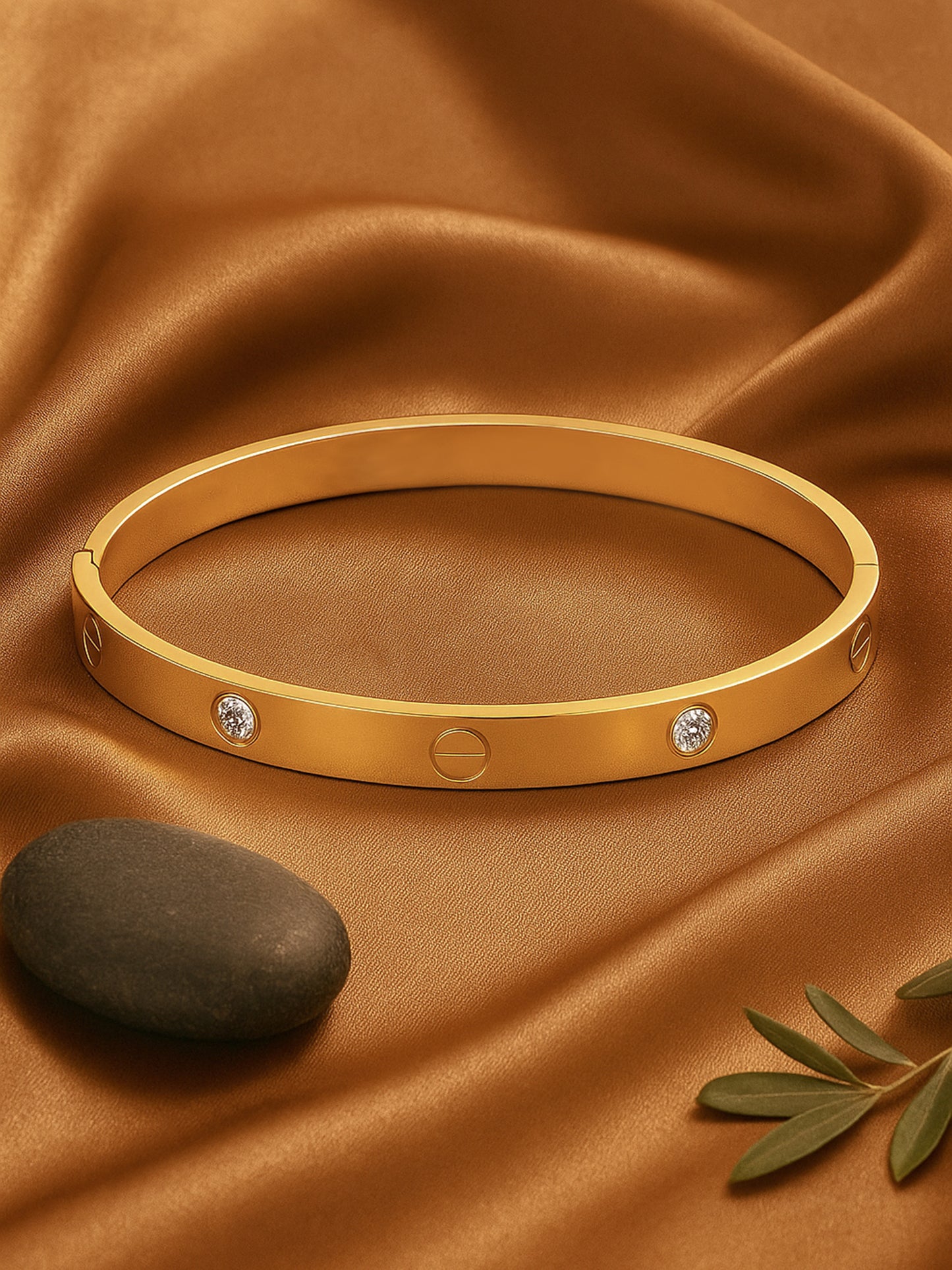 A simple bracelet for women with a classic gold band design placed on soft brown silk fabric.