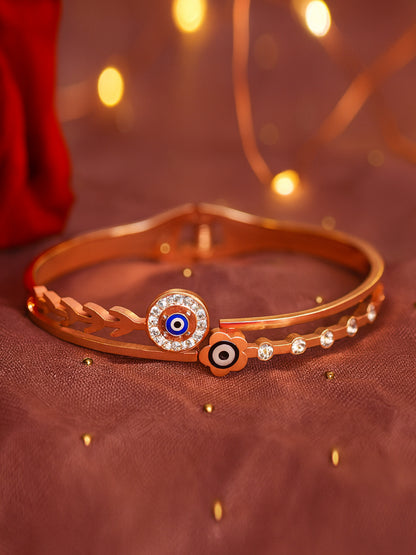 A stylish gold bracelet design for women featuring an evil eye charm and a leaf-inspired band with sparkling accents.